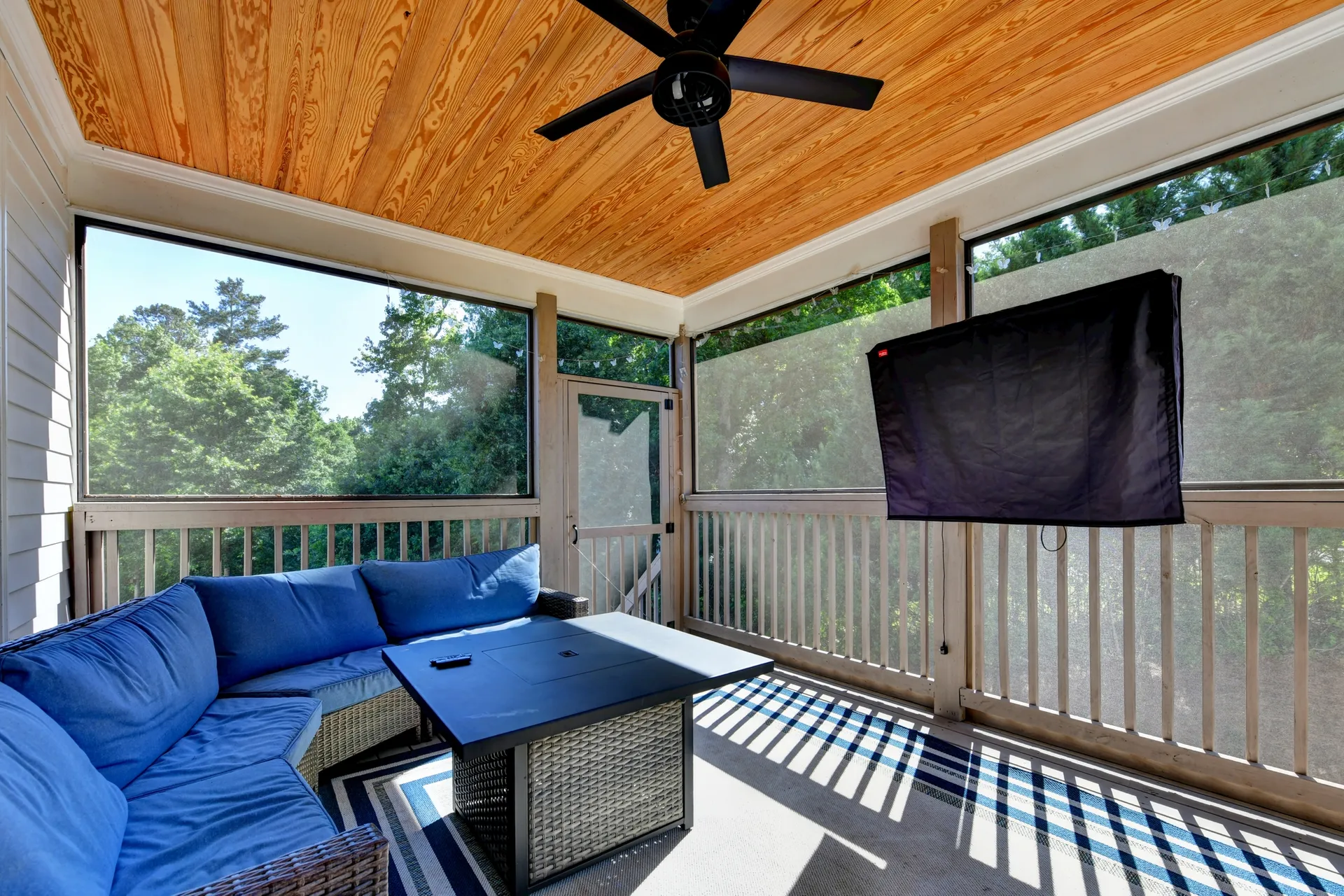 Screened porch with wood-paneled ceiling